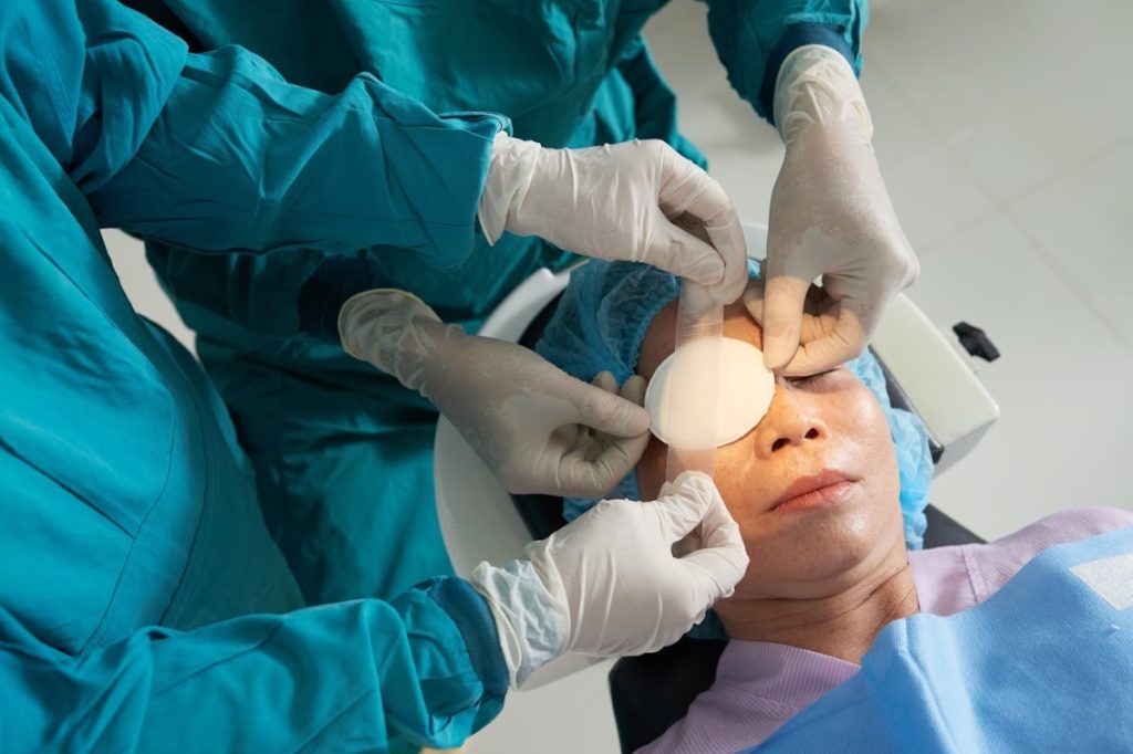 Patient undergoing vision correction surgery with protective eye covering being applied, illustrating considerations in choosing between SMILE vs LASIK for refractive error correction.